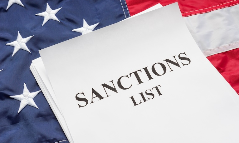 US sanctions list document on an American flag